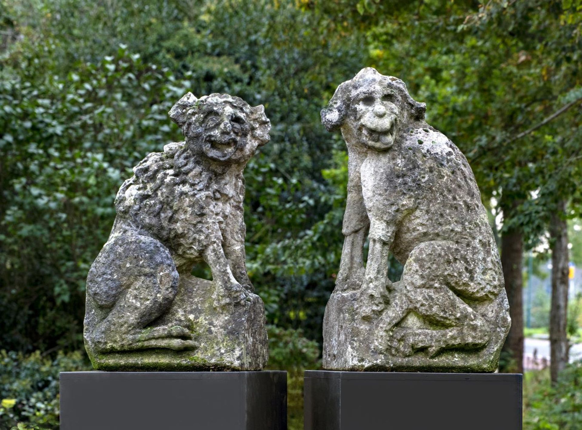 ‡ A PAIR OF FRENCH SCULPTED LIMESTONE FIGURES OF WATCHDOGS