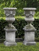 ‡ A PAIR OF CARVED LIMESTONE GARDEN URNS