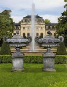 Ω A PAIR OF CARVED LIMESTONE GARDEN TWIN HANDLED URNS WITH COVERS