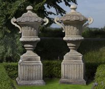 Ω A PAIR OF MONUMENTAL CARVED LIMESTONE URNS AND COVERS IN BAROQUE TASTE