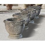 Ω A SET OF FOUR COMPOSITION STONE GARDEN PLANTERS