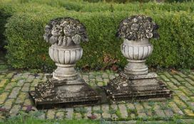 ‡ A PAIR OF CARVED LIMESTONE PIER FINIALS IN THE FORM OF FRUITING BASKETS