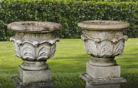 ‡ A PAIR OF FRENCH LIMESTONE GARDEN URNS ON PLINTHS