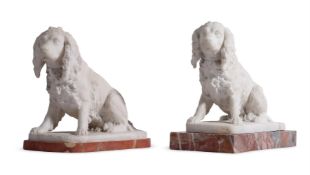 TWO SIMILAR CARVED ALABASTER MODELS OF SPANIELS EACH MOUNTED ON A PINK MARBLE BASE