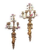 A PAIR OF GILT METAL AND PORCELAIN MOUNTED THREE BRANCH WALL APPLIQUES