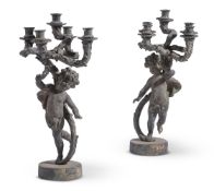 A PAIR OF PATINATED METAL FIGURAL FIVE LIGHT CANDELABRA