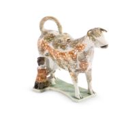 AN ENGLISH PEARLWARE MODEL OF A COW WITH MILKMAID