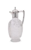 AN EDWARDIAN SILVER MOUNTED AND CUT GLASS CLARET JUG