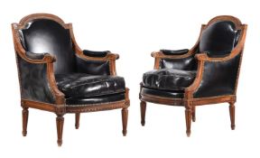 A PAIR OF CARVED WALNUT AND LEATHER UPHOLSTERED ARMCHAIRS IN FRENCH TASTE