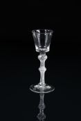 AN AIRTWIST DOUBLE-KNOPPED WINE GLASSMID 18TH CENTURYThe tapered bucket bowl on a knopped stem fil