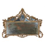 A CARVED GILTWOOD AND COMPOSITION OVERMANTEL WALL MIRROR IN GEORGE III STYLE