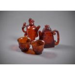 Two Chinese carved amber wine ewers and two cups