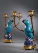 An attractive pair of Chinese ormolu mounted biscuit porcelain parrot candelabra