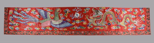 A fine Chinese red silk five coloured cloud pattern horizontal pelmet