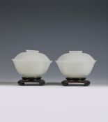 A pair of Chinese pale celadon or white jade bowls and covers