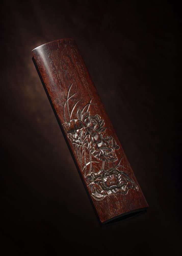 A Chinese carved 'crab and lotus' zitan wrist wrest