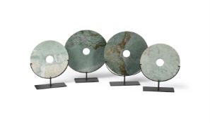 Two pairs of Chinese pale green carved hardstone discs