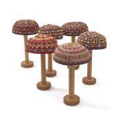 A COLLECTION OF SIX EMBROIDERED AFGHAN TRIBAL SKULL CAPS ON WOODEN HAT STANDS, AFGHAN