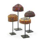 A SET OF FOUR ASIAN HAND EMBROIDERED SKULL CAPS, MID 20TH CENTURY