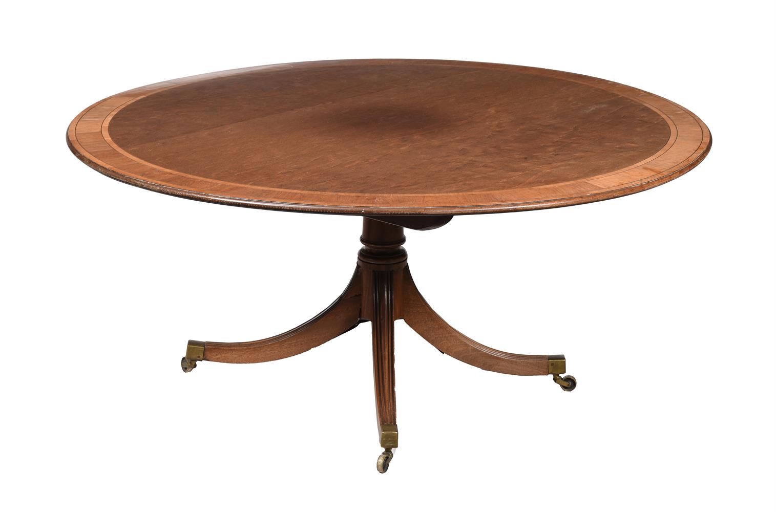 A MAHOGANY AND CROSS BANDED DINING TABLE IN REGENCY STYLE