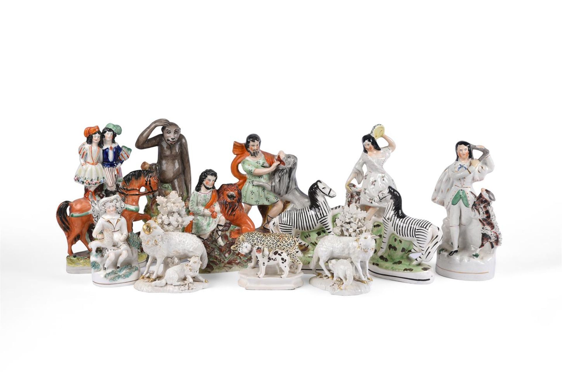 A SELECTION OF MOSTLY STAFFORDSHIRE POTTERY MODELS OF ANIMALS AND THEATRICAL GROUPS