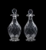 A PAIR OF CUT GLASS POURING DECANTERS AND STOPPERS