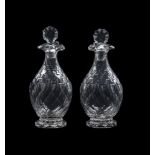 A PAIR OF CUT GLASS POURING DECANTERS AND STOPPERS