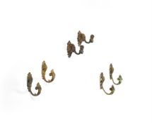 A GROUP OF THREE PAIRS OF FRENCH GILT METAL CURTAIN TIE-BACKS
