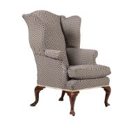 A GEORGE II WALNUT AND UPHOLSTERED WING ARMCHAIR