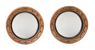 A PAIR OF GILTWOOD CIRCULAR CONVEX WALL MIRRORS IN LATE GEORGE III STYLE