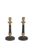 A PAIR OF PATINATED AND GILT METAL CANDLESTICKS IN EMPIRE STYLE