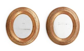 A PAIR OF GILTWOOD AND COMPOSITION OVAL MIRRORS, 19TH CENTURY