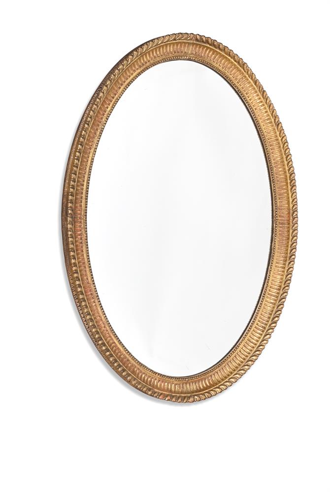 A GEORGE III CARVED GILTWOOD OVAL MIRROR, CIRCA 1800