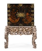 A BLACK LACQUER AND DECORATED CABINET ON SILVERED STAND