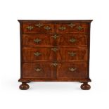 A QUEEN ANNE FIGURED WALNUT AND FEATHER-BANDED CHEST OF DRAWERS, CIRCA 1710