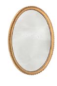 A GEORGE III CARVED GILTWOOD OVAL MIRROR, CIRCA 1775