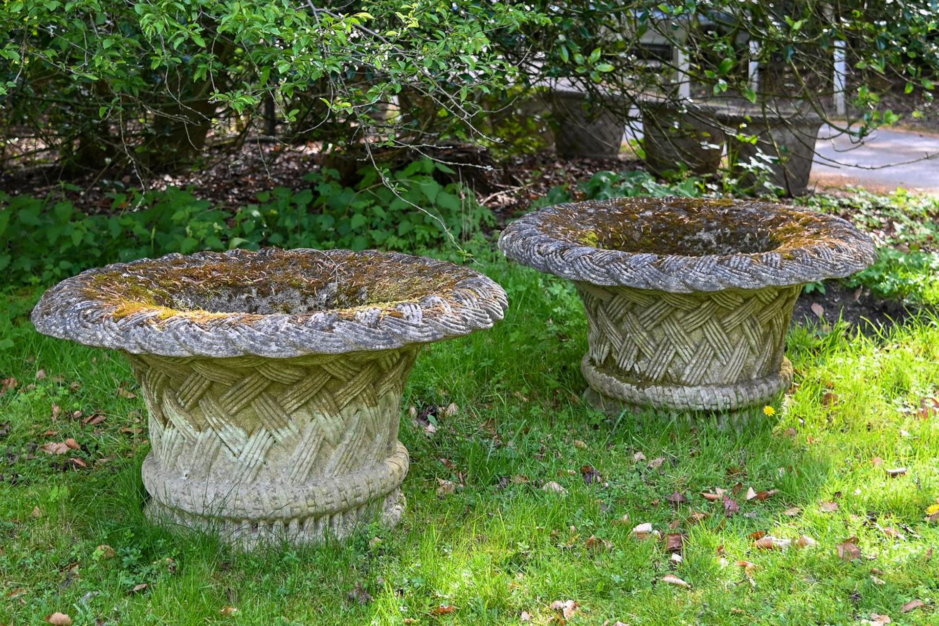 A LARGE PAIR OF MOSS WEATHERED COMPOSITION STONE GARDEN URNS, LATE 20TH CENTURY