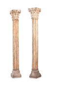 A PAIR OF CARVED WOOD AND PAINTED CORINTHIAN COLUMNS ON STONE PLINTHS, 19TH OR 20TH CENTURY