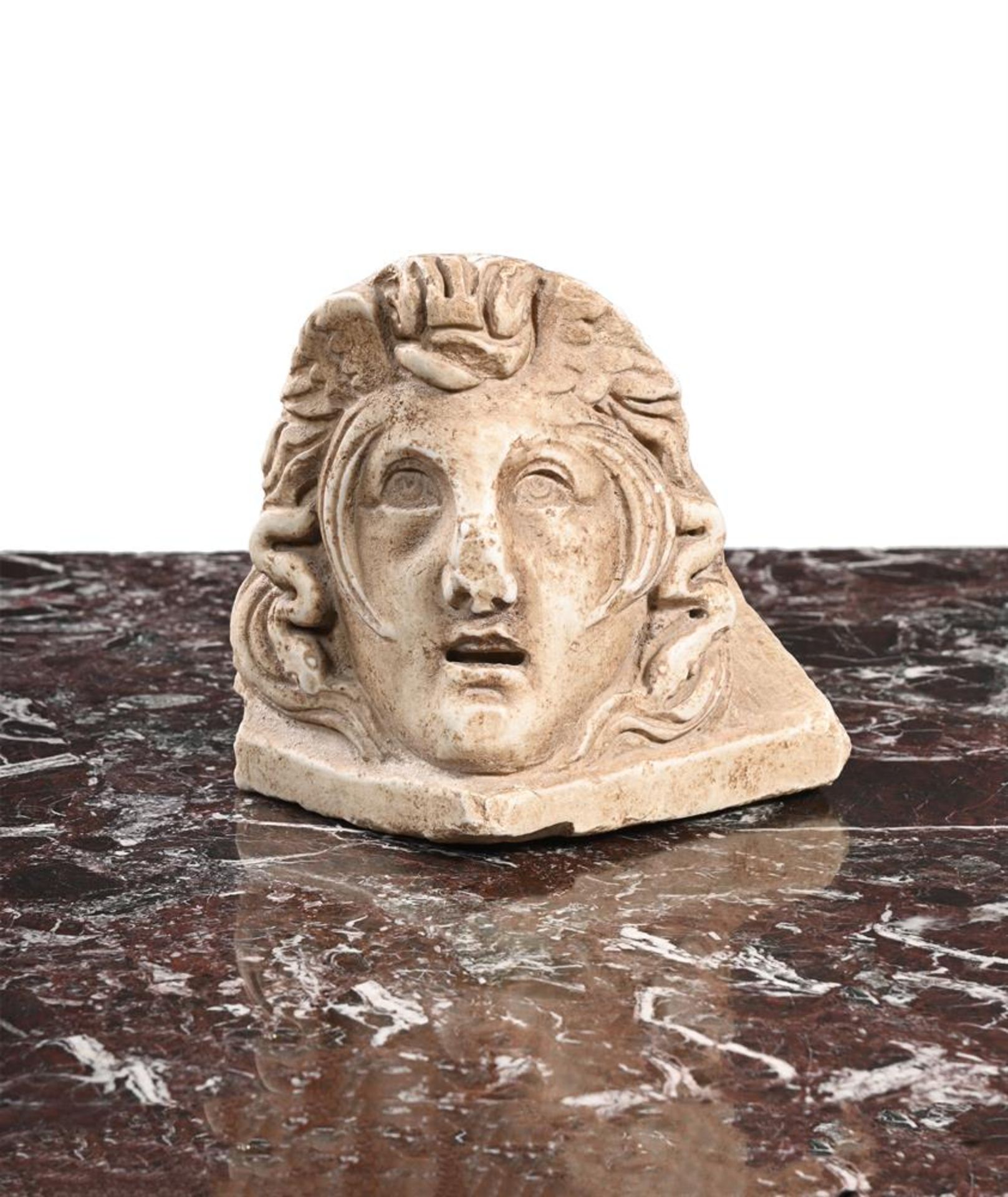 A CARVED WHITE MARBLE ACROTERIUM CORNER STONE OF MEDUSA, ITALIAN, 18TH OR 19TH CENTURY