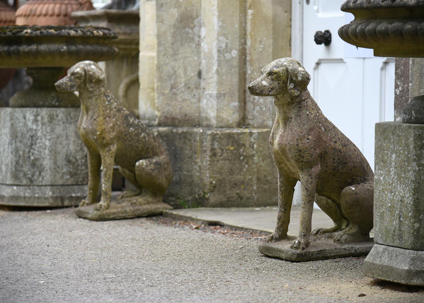 A PAIR OF COMPOSITION STONE MODELS OF SEATED HOUNDS, 20TH CENTURY