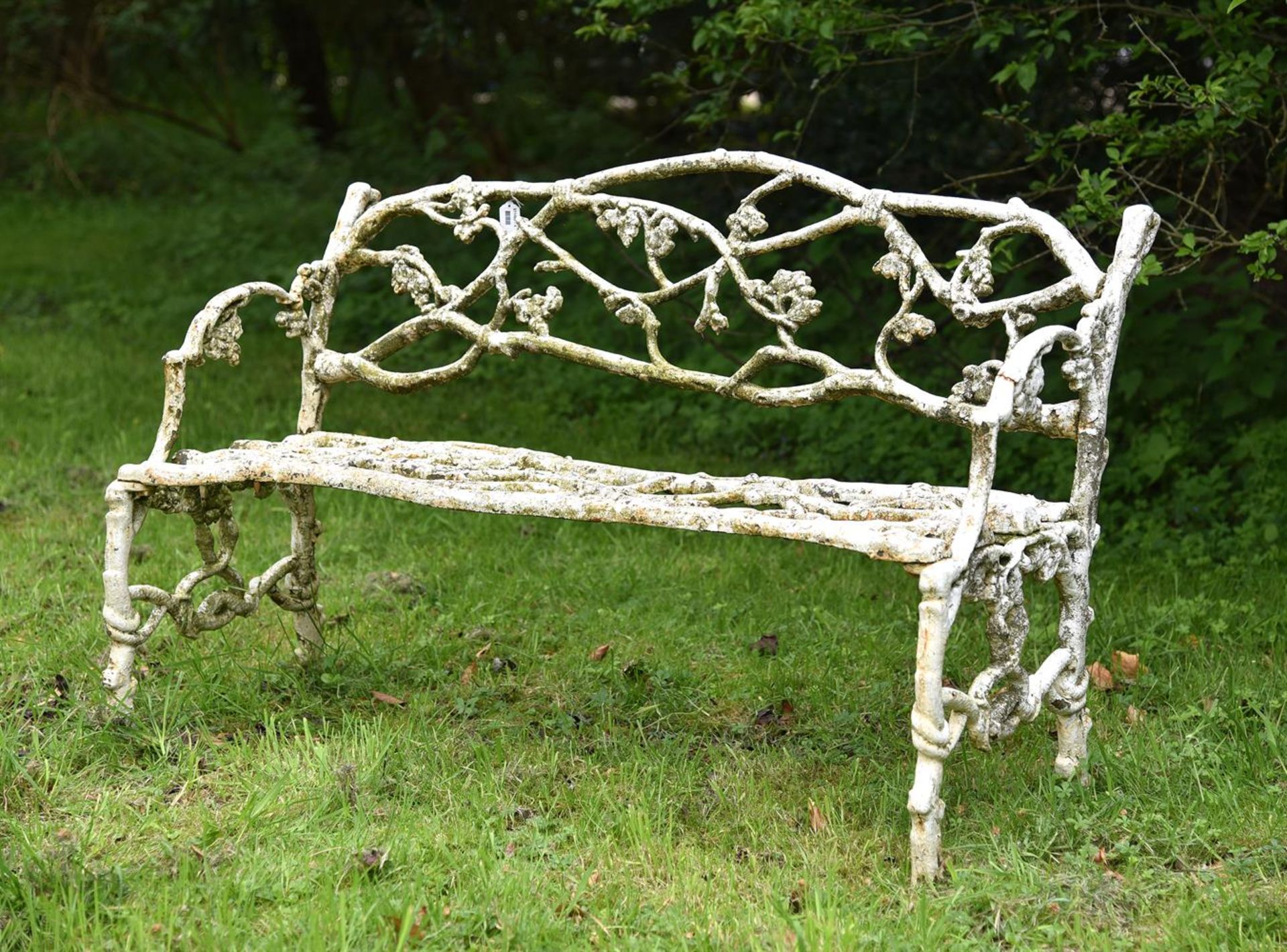 A WEATHERED WHITE PAINTED CAST IRON 'GARDEN BRANCH' BENCH, PROBABLY EARLY 20TH CENTURY