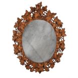 A GERMAN 'BLACK FOREST' CARVED SOFTWOOD OVAL MIRROR, LATE 19TH CENTURY