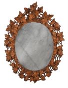 A GERMAN 'BLACK FOREST' CARVED SOFTWOOD OVAL MIRROR, LATE 19TH CENTURY