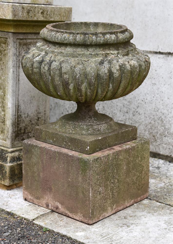 A PAIR OF STONE COMPOSITION VASES ON PLINTHS, 20TH CENTURY