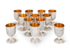 A SET OF TWELVE SILVER COLOURED CUPS