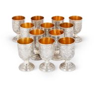 A SET OF TWELVE SILVER COLOURED CUPS