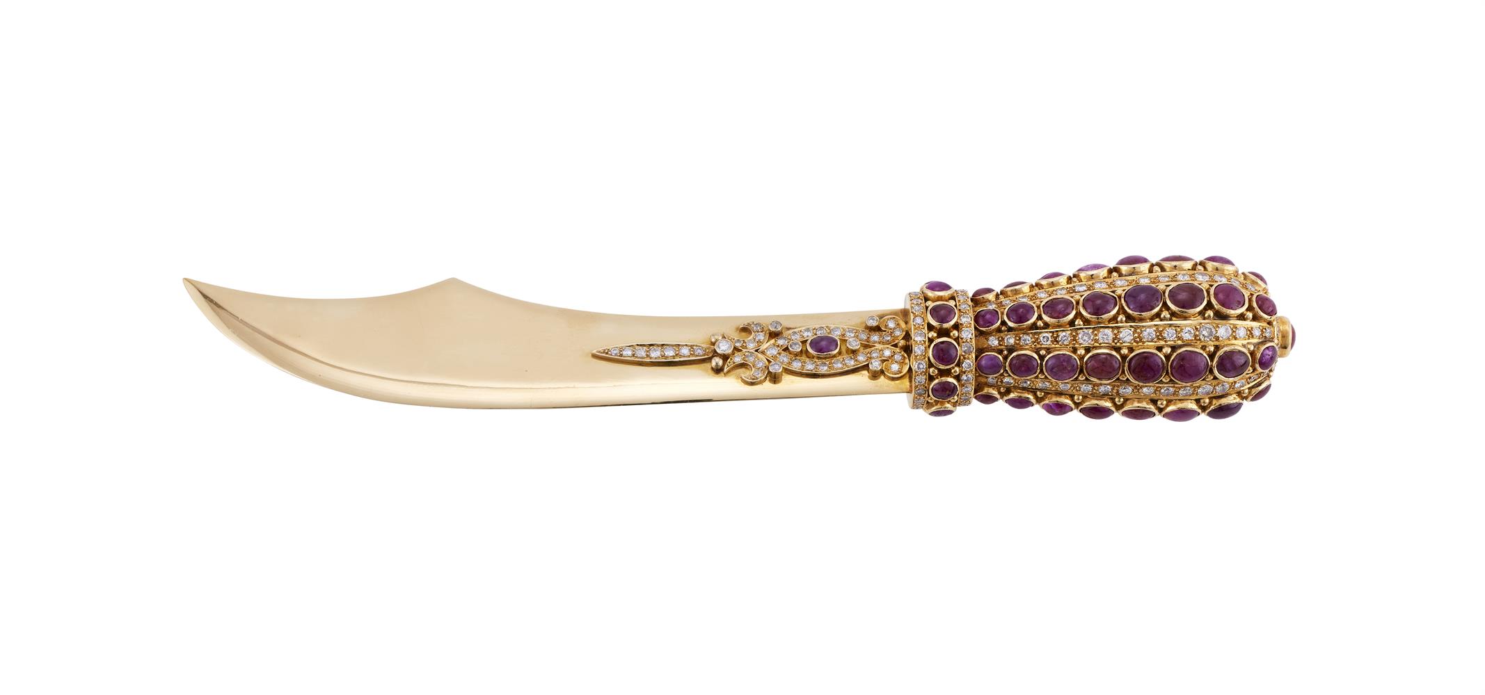 A GOLD COLOURED DIAMOND AND RUBY LETTER OPENER IN THE FORM OF A SMALL SCIMITAR