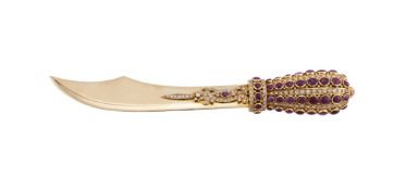 A GOLD COLOURED DIAMOND AND RUBY LETTER OPENER IN THE FORM OF A SMALL SCIMITAR