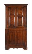 AN EARLY GEORGE III OAK DOUBLE CORNER CABINET