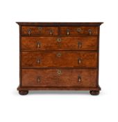 A BURR WALNUT AND FEATHER BANDED CHEST OF DRAWERS